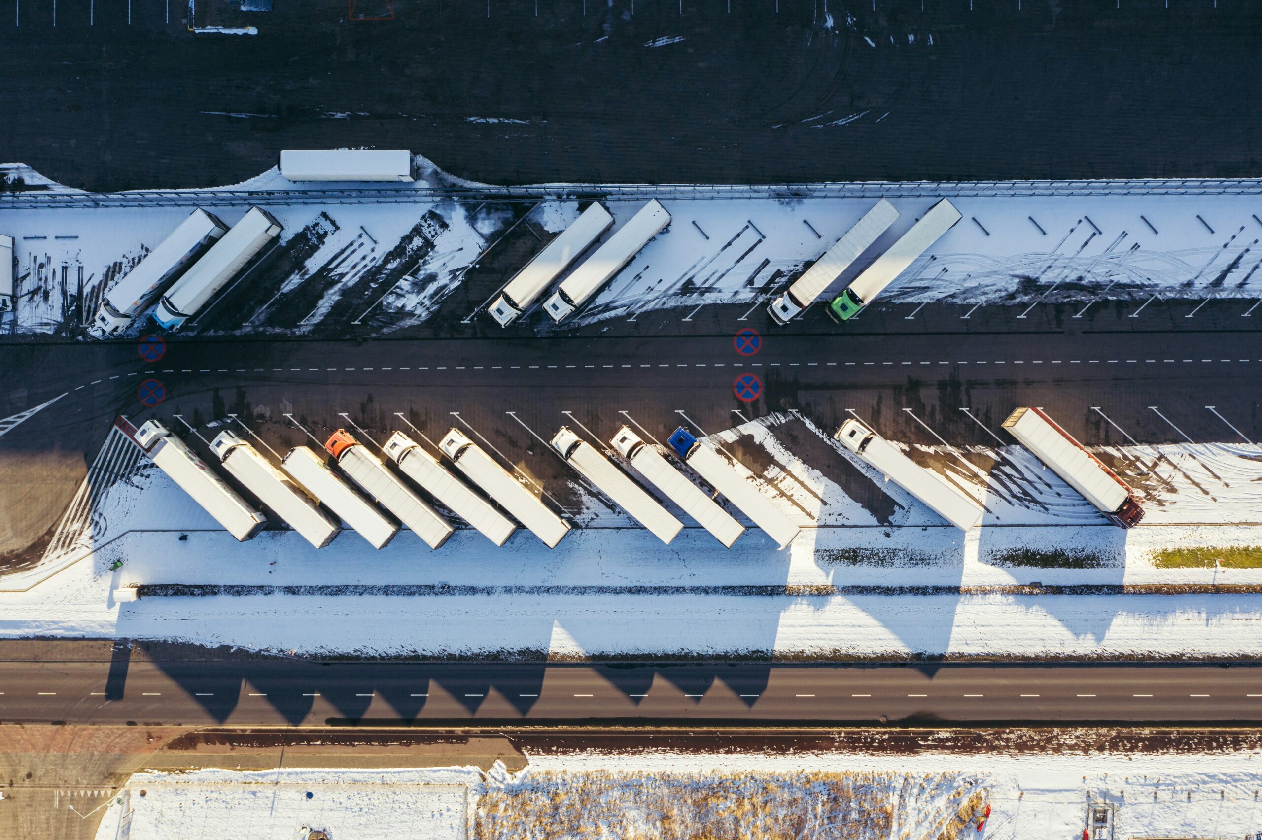 Aerial view of a wintery logistics hub with parked trucks